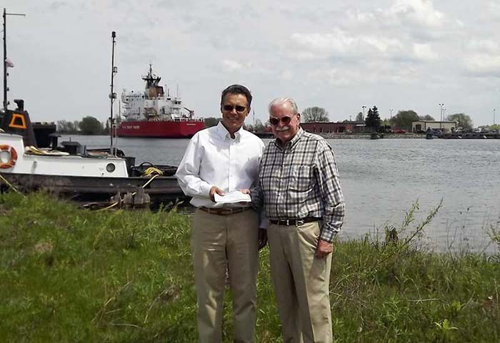 two men standing by water