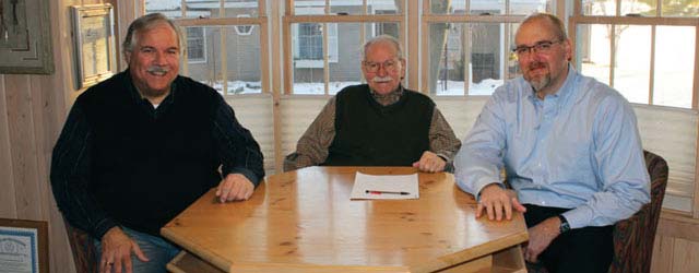 three men sitting at table